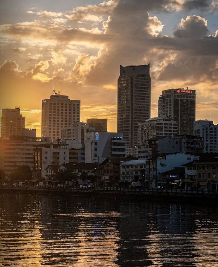 A city skyline over water at sunset